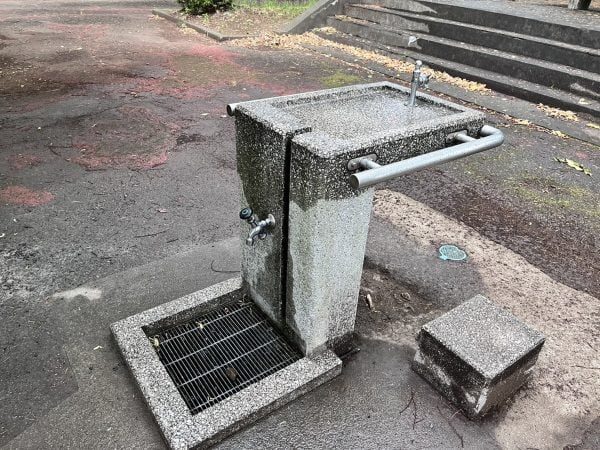 ドッグラン付近に設置された水飲み場。足洗いに使えるグレーチングも併設されている（リビング多摩Web撮影）